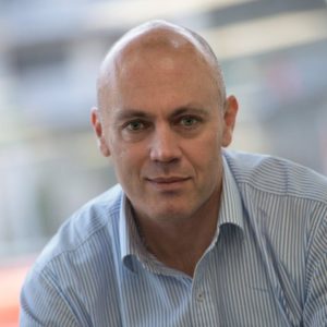 Rob Napier - a bald man in a blue shirt looking at the camera.