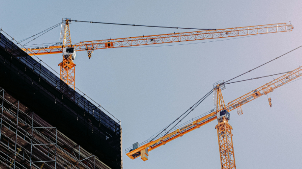 Cranes working on a building on a sunny day