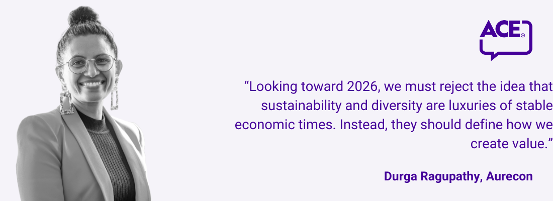 Durga Ragupathy, dark hair in bun, glasses, big earrings, smiling.