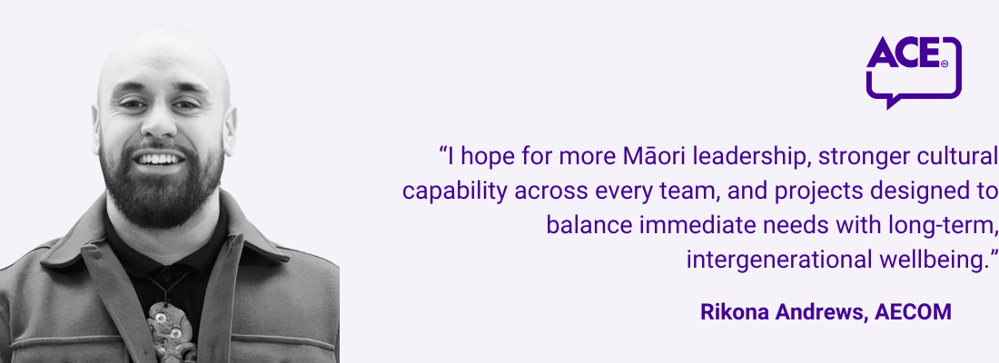 Rikona Andrews, Māori man, bald with beard, smiling, wearing a tiki.