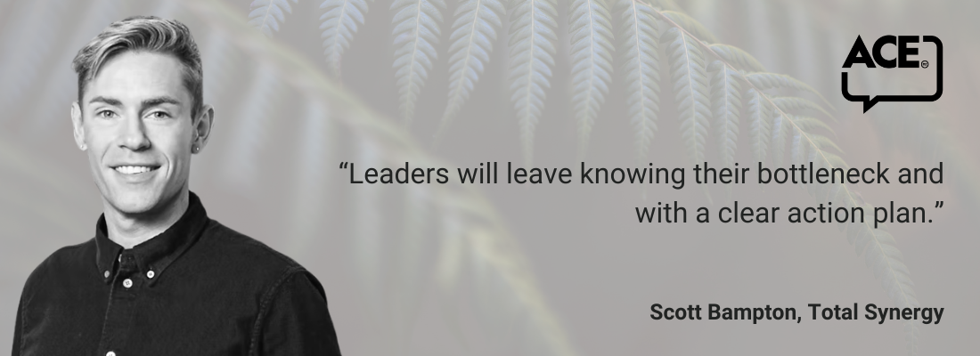 White male, blonde hair, earrings, dark shirt, smiling.
