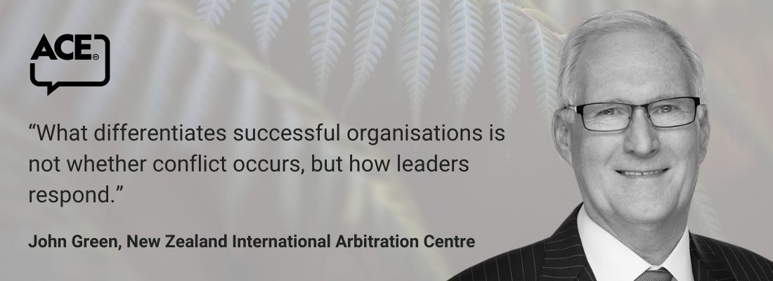 White male, grey hair, glasses, suit, smiling.