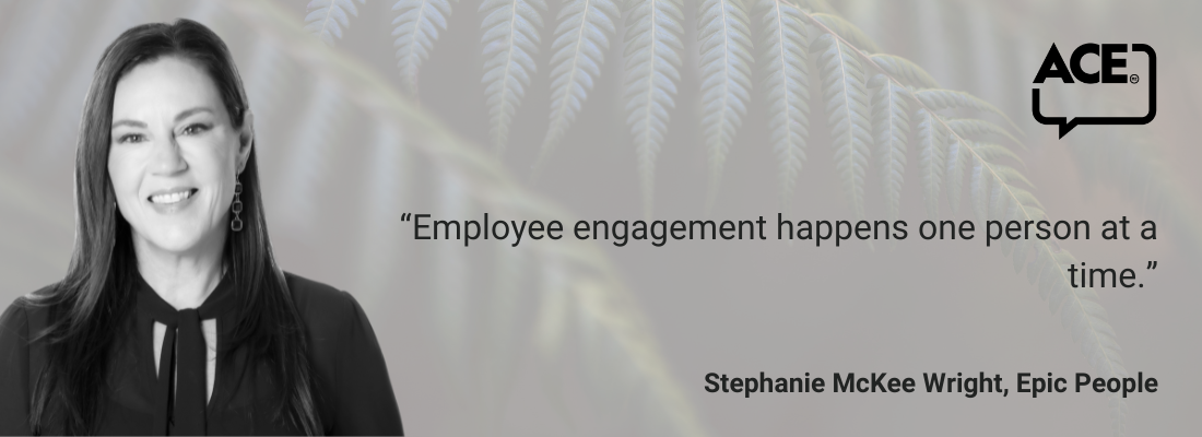 White female, shoulder-length dark hair, smiling, earrings, dark shirt.
