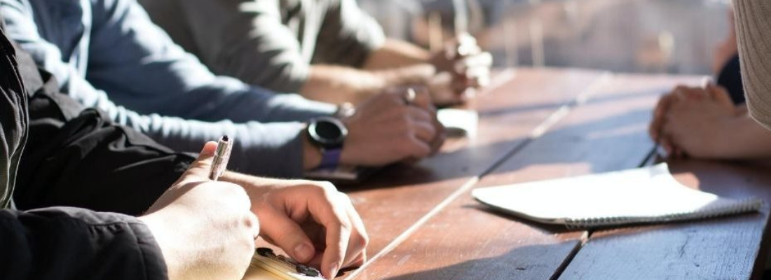 A group of people's hands on a meeting table in an office