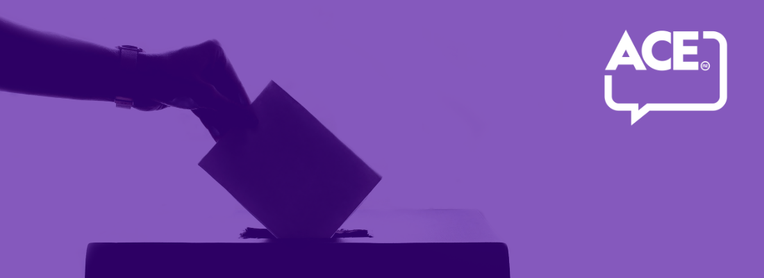 A hand putting a voting paper into a polling box with a purple background,