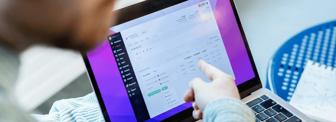 A closeup of a person pointing at a laptop screen