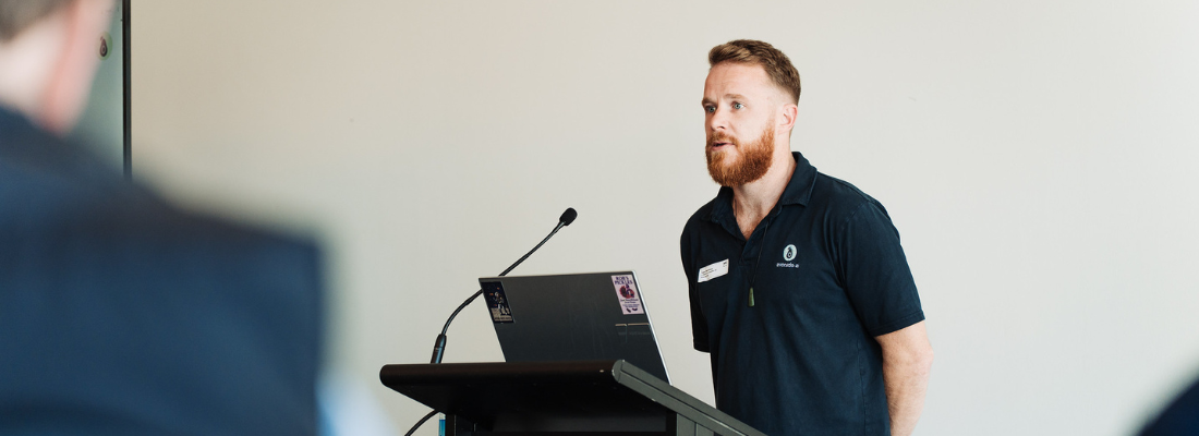 Cowan Henderson standing at a podium with a microphone
