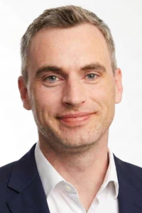 White male, smiling, headshot, suit.