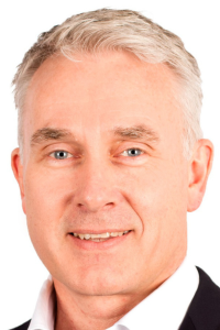White male, grey hair, blue eyes, headshot, smiling, suit.