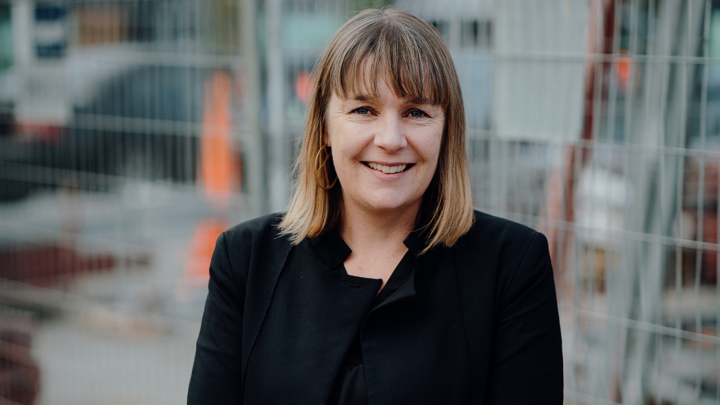 White female, smiling, shoulder length brown hair, suit.