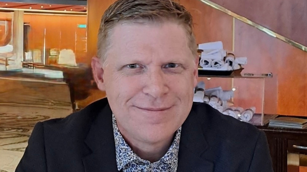 White male, fair haired, smiling, suit.