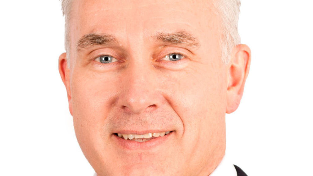 White male, smiling, grey hair, blue eyes.
